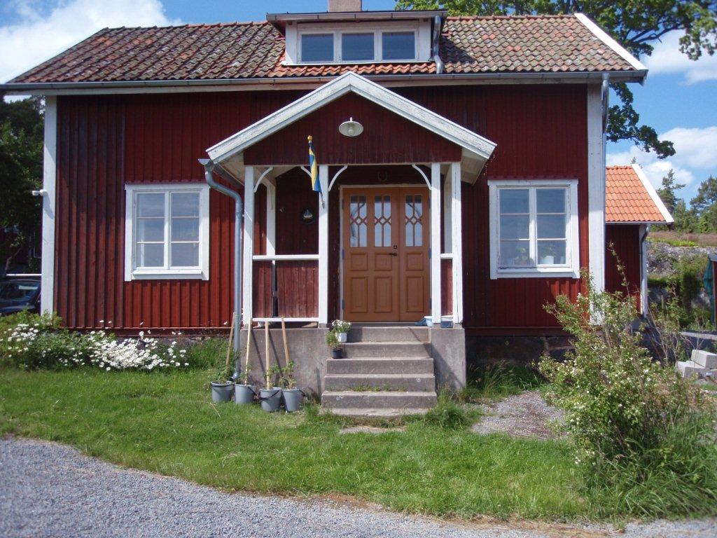 Rödmålat hus med handtillverkade fönster och ytterdörr från Fönsterfabriken i Östra Ryd